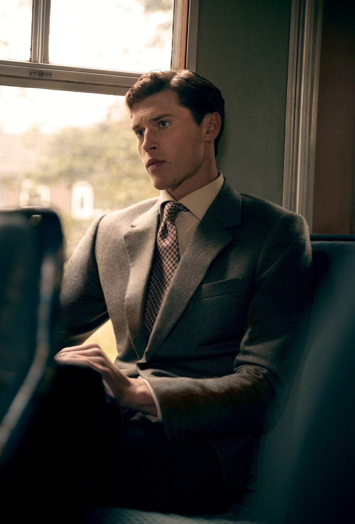 Gentleman in necktie sits on a train