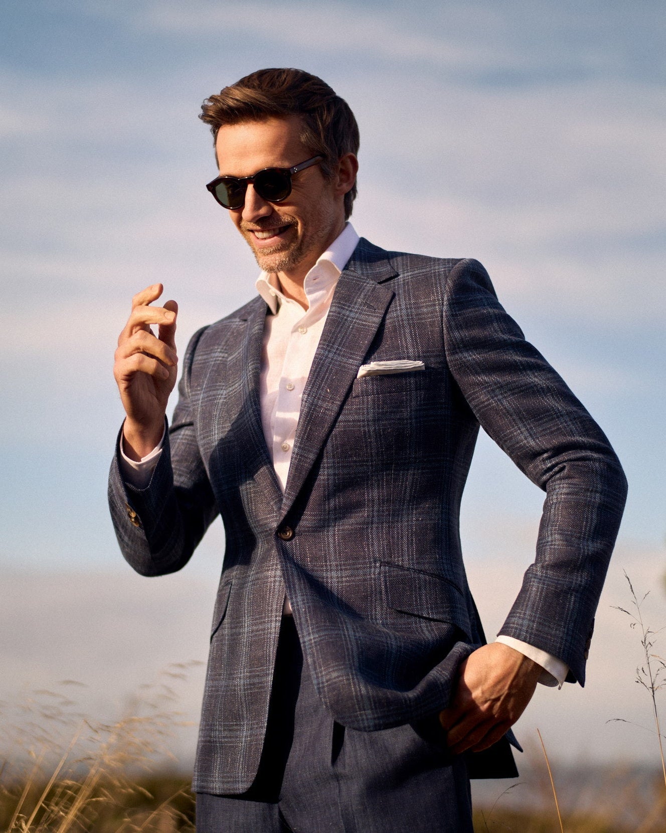Model wearing a Huntsman navy and blue overcheck wool, silk and linen single breasted suit from the Spring-Summer 2026 collection