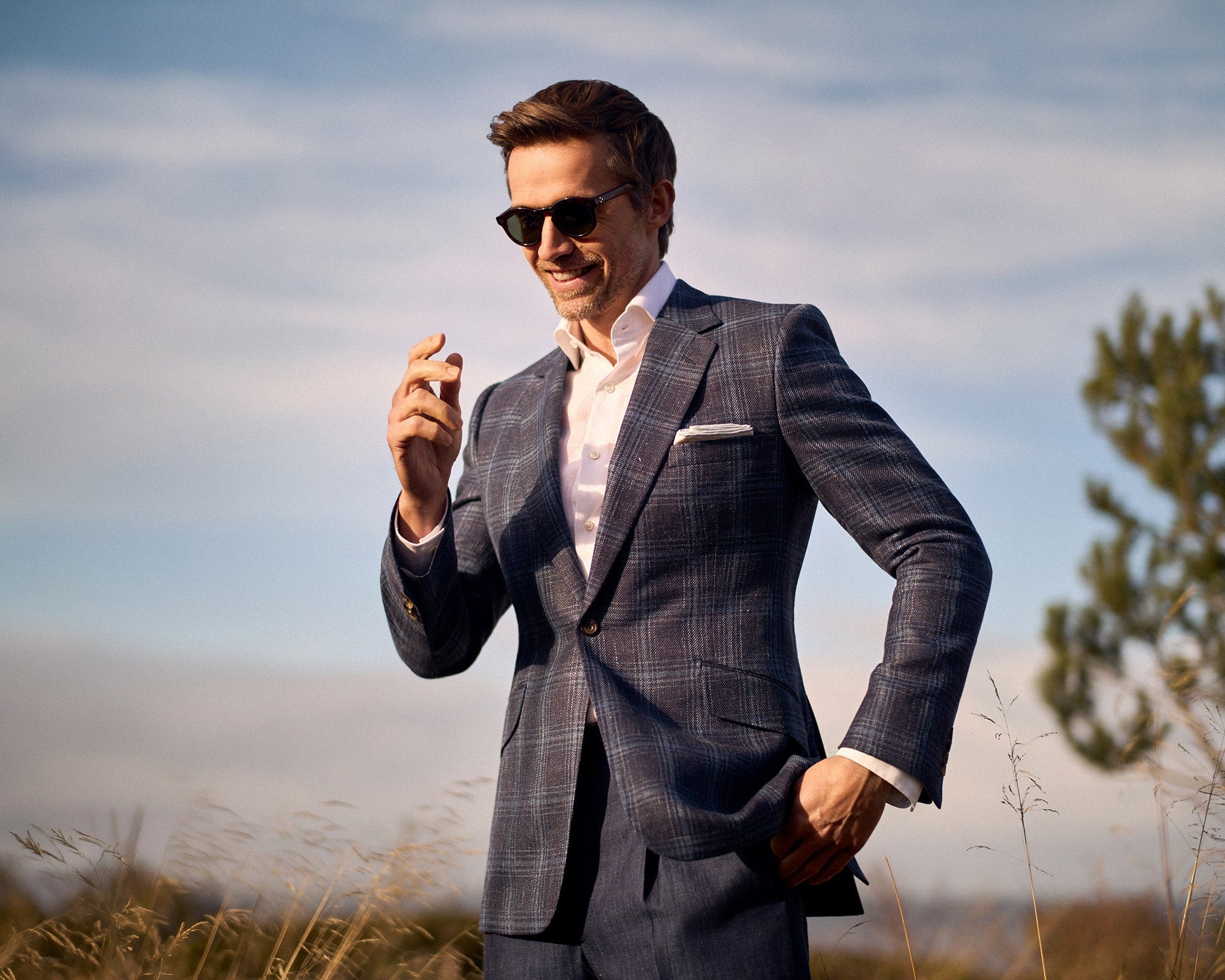 Model wearing a Huntsman navy and blue overcheck wool, silk and linen single breasted suit from the Spring-Summer 2026 collection