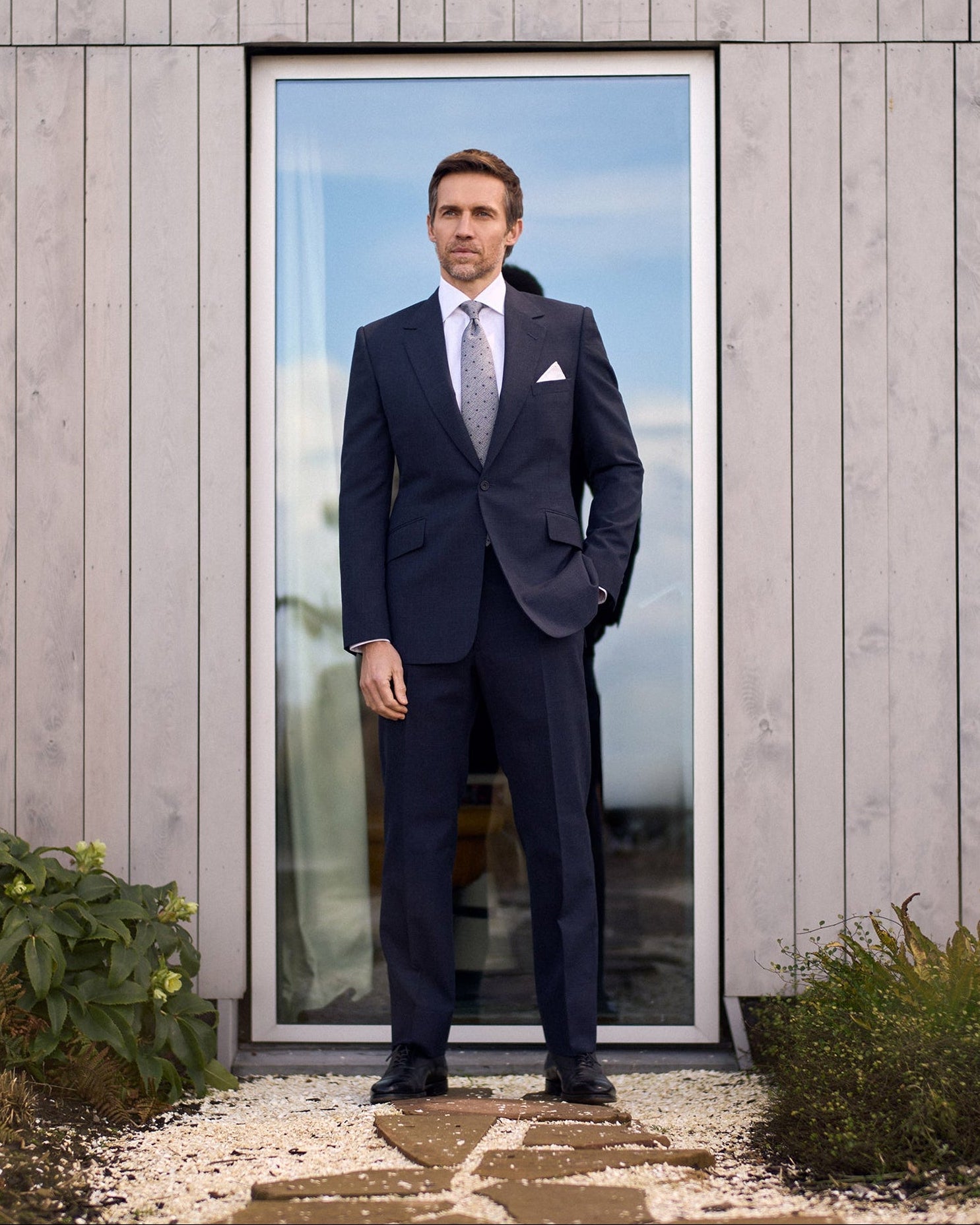 Model wearing the Huntsman indigo micro houndstooth single breasted suit from the Spring-Summer 2026 ready-to-wear collection