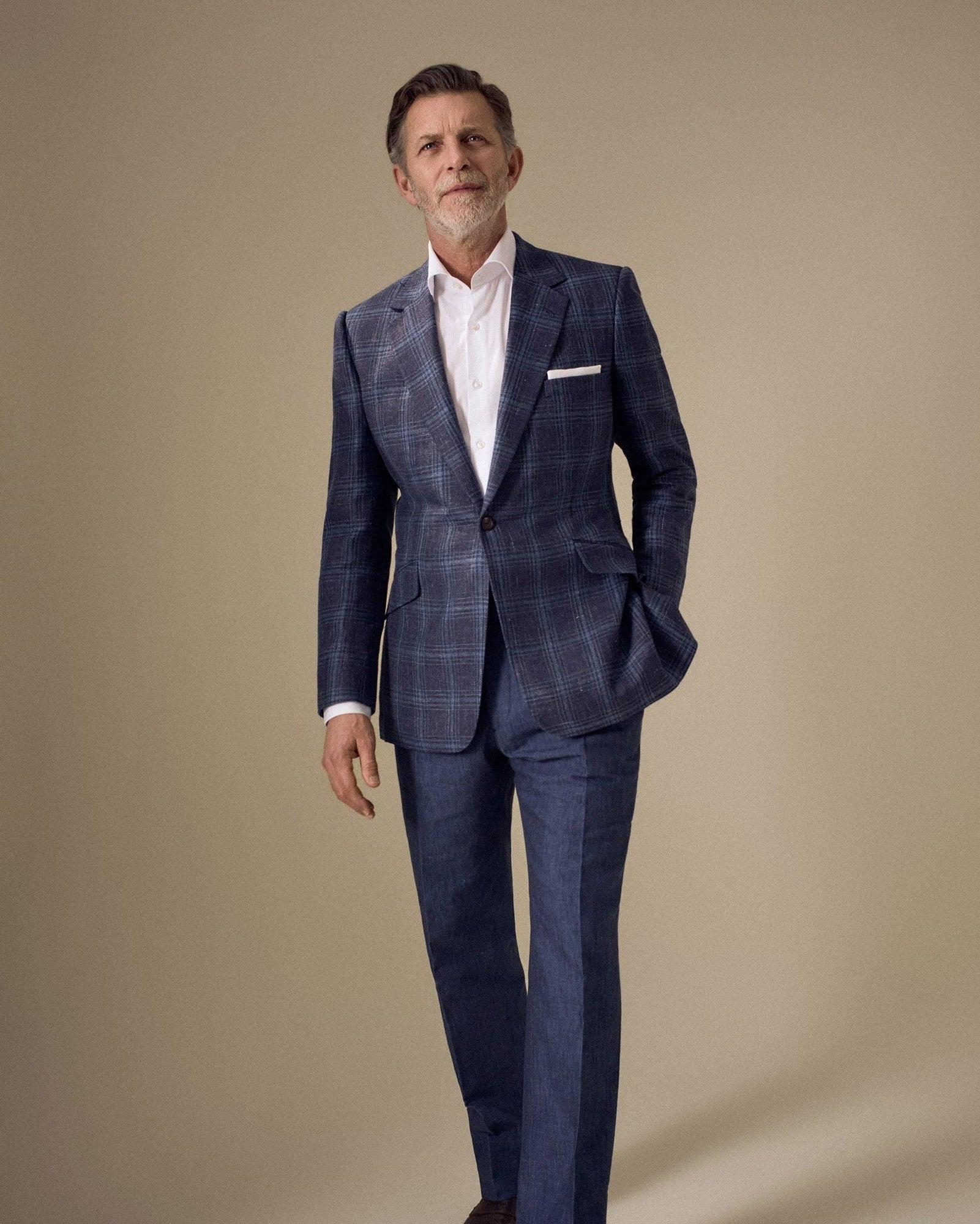 Model wearing a Huntsman navy blue overcheck single breasted jacket from the Spring-Summer 2026 ready-to-wear collection